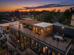 Un edificio de varios pisos con zonas de estar al aire libre, grandes ventanales y vistas del paisaje circundante.