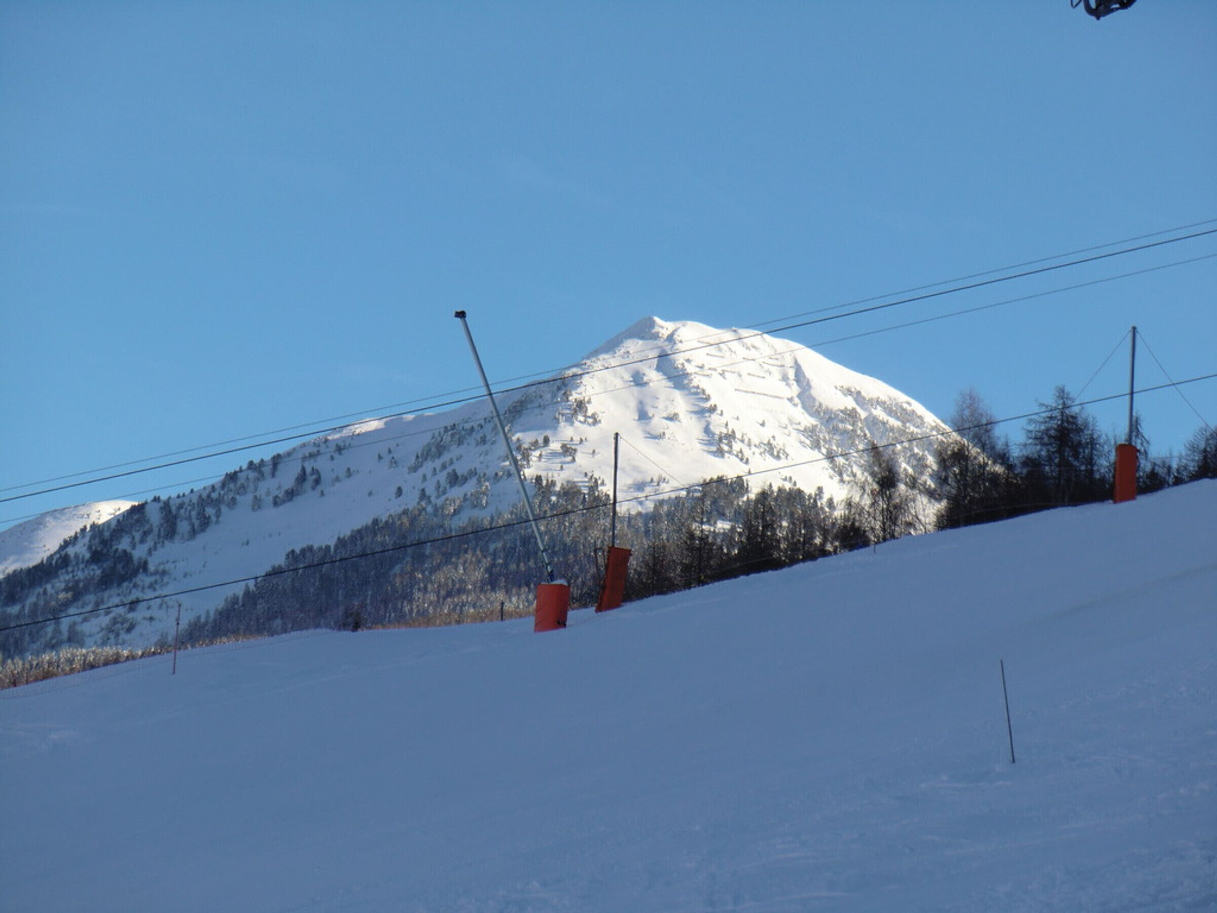 A snow-covered mountain with a clear sky.