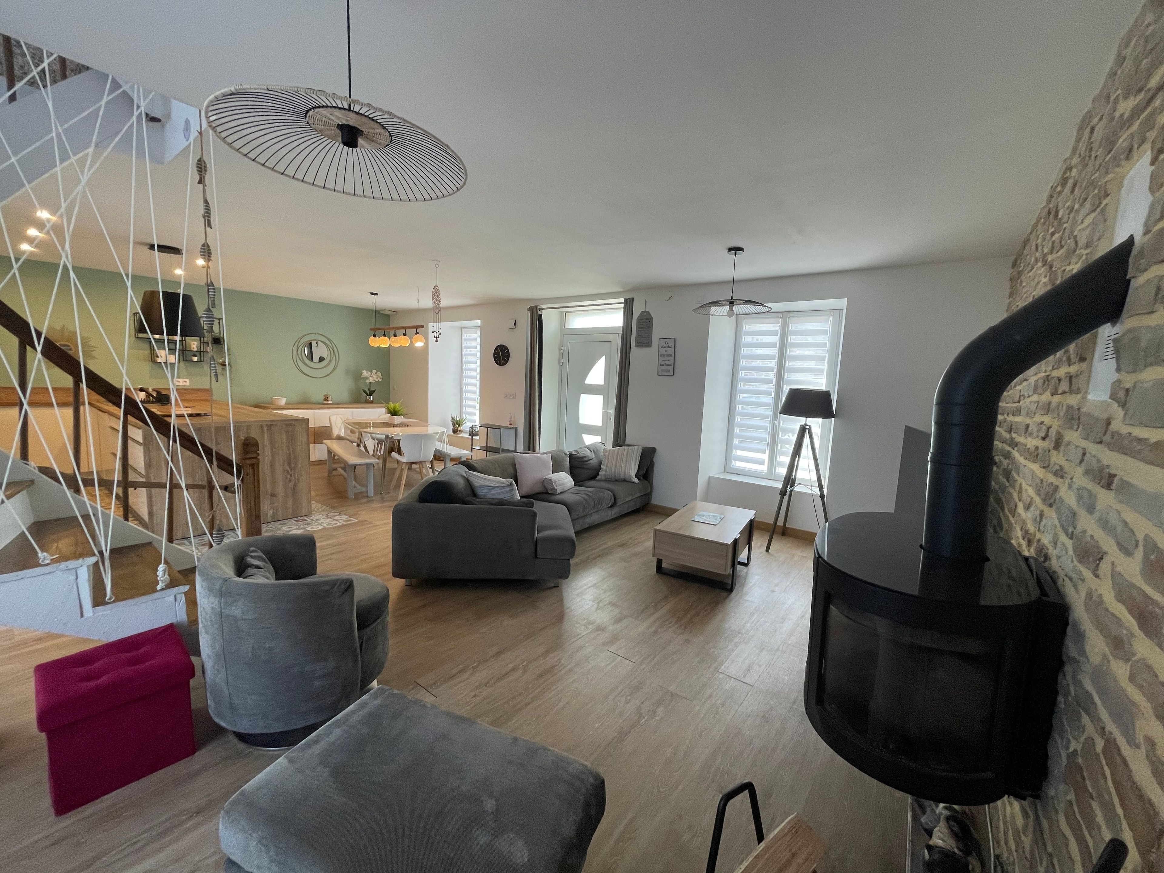 Un salon moderne avec un canapé, un pouf et une cheminée.