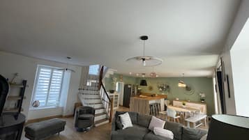 Un amplio espacio habitable con una escalera, un comedor y una cocina.