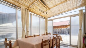 Un comedor con una mesa dispuesta para seis personas, rodeada de sillas de madera con asientos de mimbre.