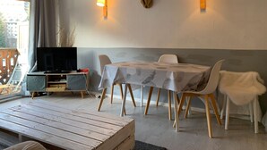 A dining area with a table, chairs, and a mounted deer head on the wall. - Spacious Studio in Pra-Loup 1600 | 4 pers, balcony, WIFI (Pra-Loup)