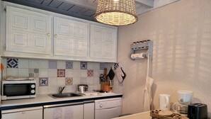 A kitchen with white cabinets, a microwave, a sink, and a coffee maker. - Spacious Studio in Pra-Loup 1600 | 4 pers, balcony, WIFI (Pra-Loup)