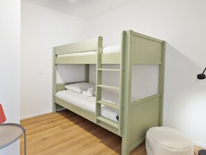 A bunk bed with a ladder, a small table, and a chair in a room with wooden flooring and white walls. - Family apartment 4 adults + 4 children, near village, parking (Le Monêtier-les-Bains)