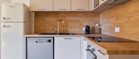 A modern kitchen with a dishwasher, a sink, and a coffee maker.
