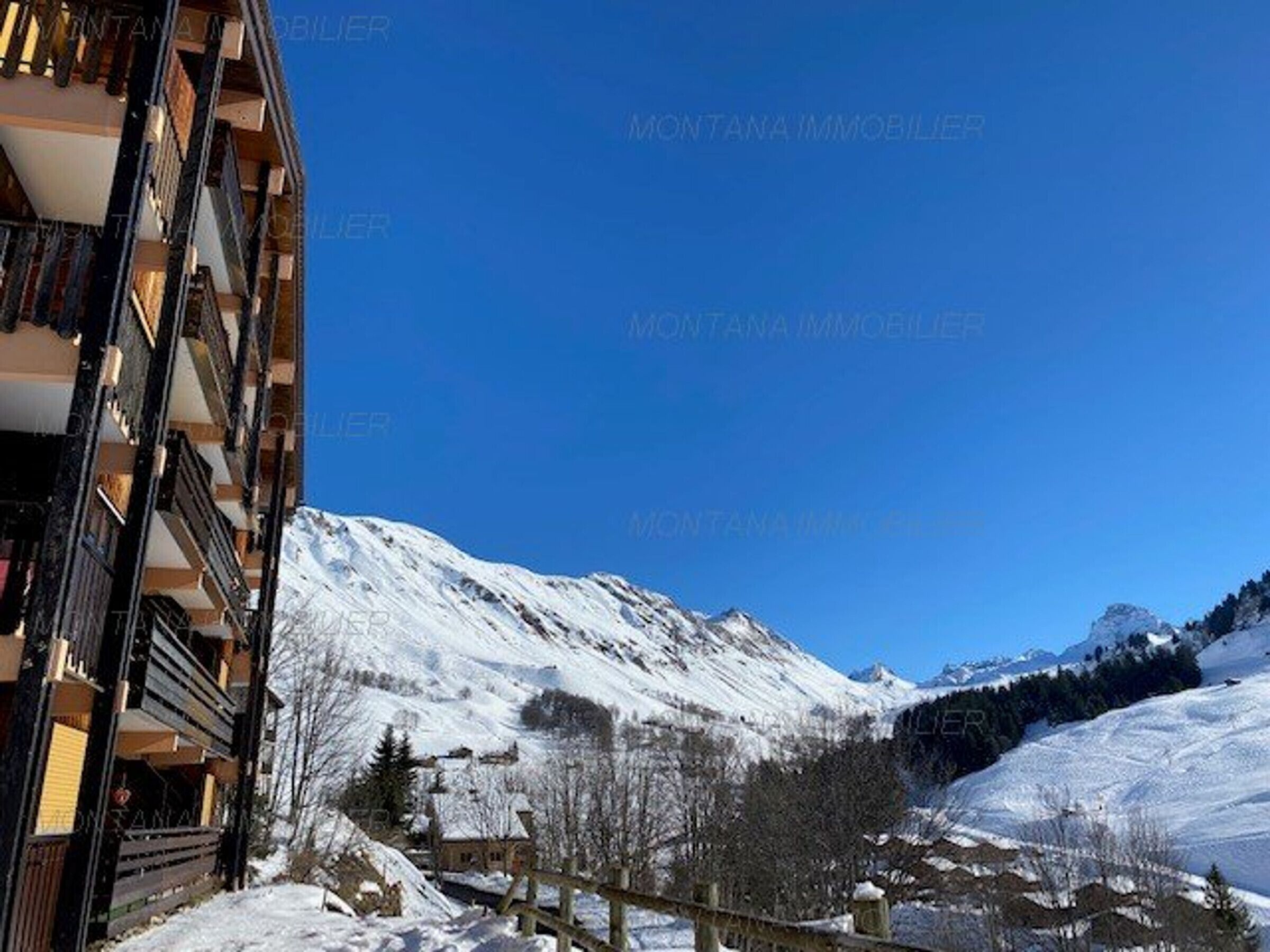 A snow-covered mountain landscape with a building featuring balconies.
