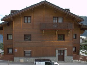 Un edificio de madera de varios pisos con un balcón, un letrero que dice 