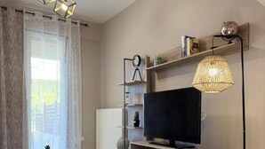 A modern living room with a flat-screen TV, a bean bag chair, and a dining table.