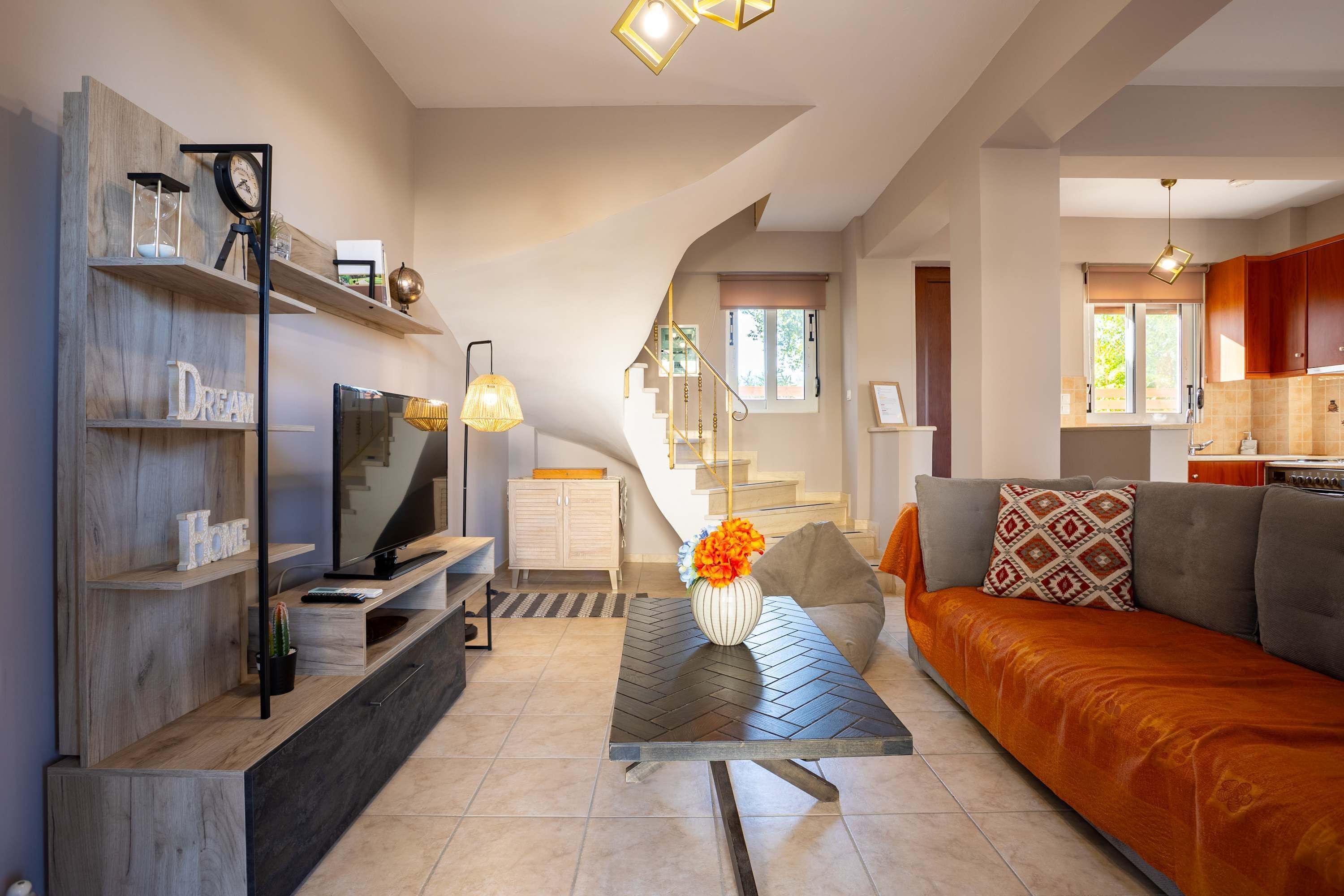 A modern living room with a sofa, coffee table, TV, and decorative items.