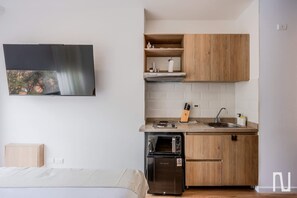 A compact kitchen with wooden cabinets, a built-in microwave, and a sink.