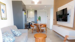 Ein modernes Wohnzimmer mit einer Couch, einem Couchtisch und einem an der Wand montierten Fernseher.