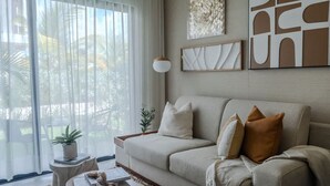 Ein Wohnzimmer mit einem beigen Sofa, einem Couchtisch und einer Topfpflanze.