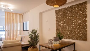 Una sala moderna con un sofá, una mesa de madera y un panel decorativo en la pared.