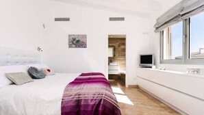 A modern bedroom with a bed, a TV, and a window. - Bouganvilla House FOR 6 PERSONS (Ariany)