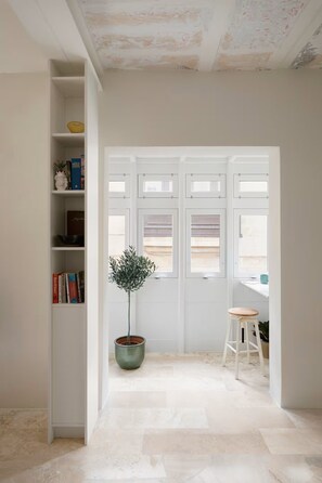 A room with a white door, a potted plant, and a bookshelf. - Immerse yourself in Malta's local culture whilst enjoying a contemporary home! (Cospicua)