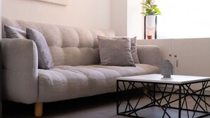 A modern living room with a grey sofa, a geometric coffee table, and a minimalist abstract painting on the wall. - NOK Beatiful Loft in Chic (Bogotá)
