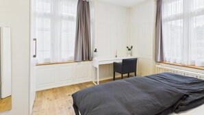 Un dormitorio moderno con una cama, un escritorio y una silla.