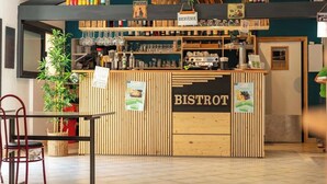 A bistro with a wooden counter, shelves with bottles, and a sign that reads "BISTROT". - Camping Marvilla Parks - Clos Cottet (Angles)