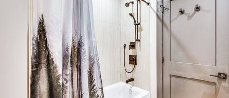 Un baño con bañera, ducha y puerta.