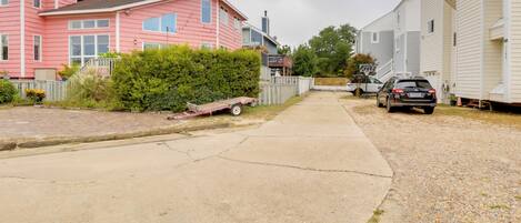Una calle residencial con casas, una entrada de vehículos y un automóvil estacionado.