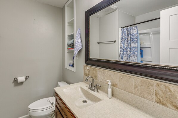 A bathroom with a toilet, sink, mirror, and towel rack. - 2 Mi to Zoo, Fenced Yard: Family Home in Wichita! (Wichita)