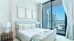 Een moderne slaapkamer met een groot bed, nachtkastjes en uitzicht op een stadsgezicht vanaf een balkon.