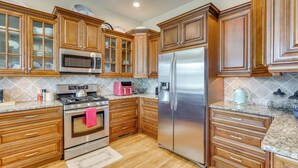 A kitchen with wooden cabinets, stainless steel appliances, and a tiled backsplash. - Explore Historic Dtwn! Walkable Loft in Murphy (Murphy)