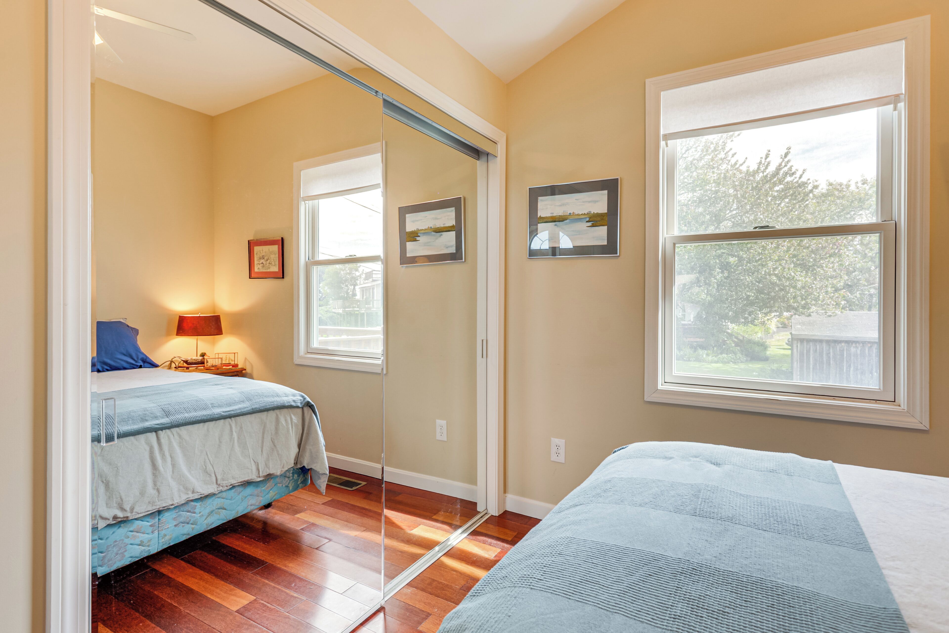 Um quarto com cama, mesa de cabeceira, luminária e janela com vista para o exterior.