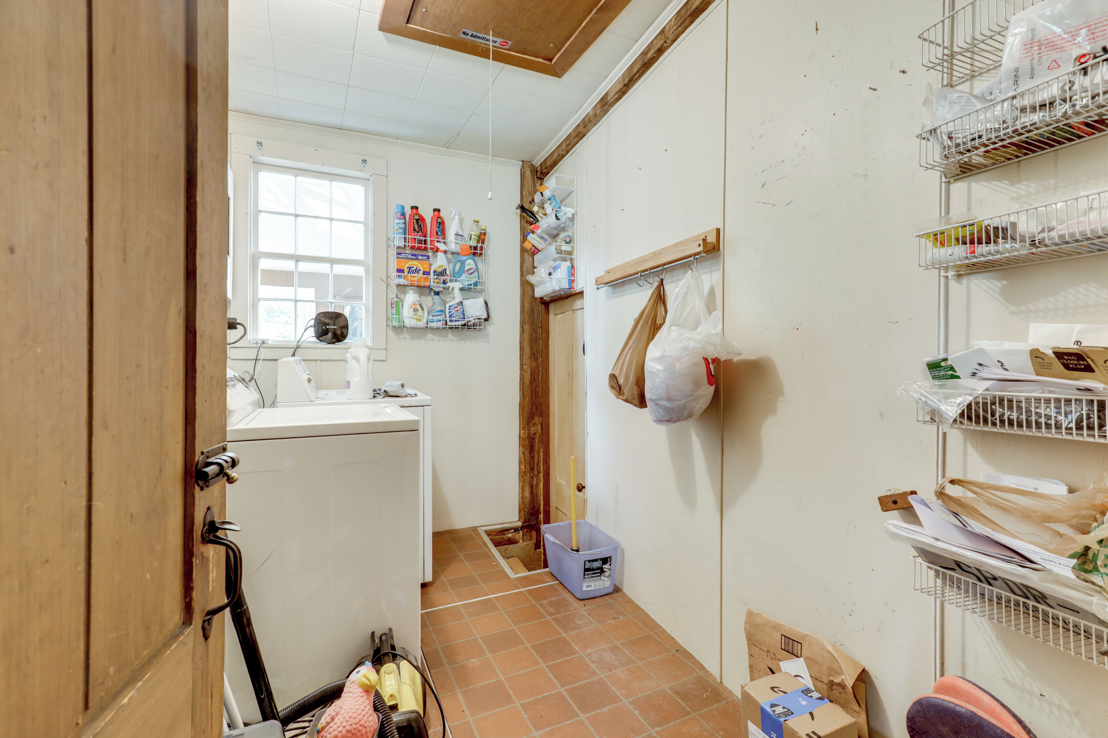 A compact kitchen with a refrigerator, sink, and various storage shelves.