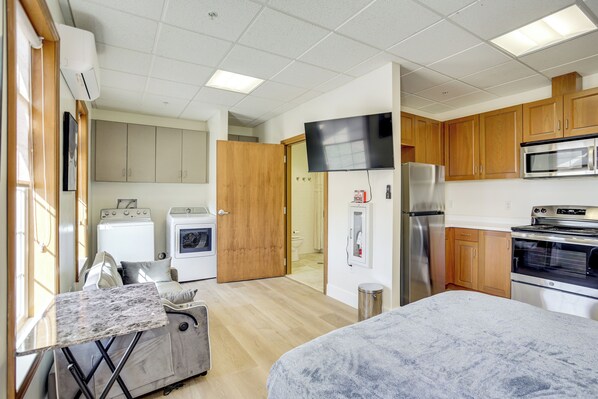 A compact kitchen with wooden cabinets, a microwave, a refrigerator, and a washing machine. - Mtn-view Escape 9 Mi to Crystal Hot Springs (Tremonton)
