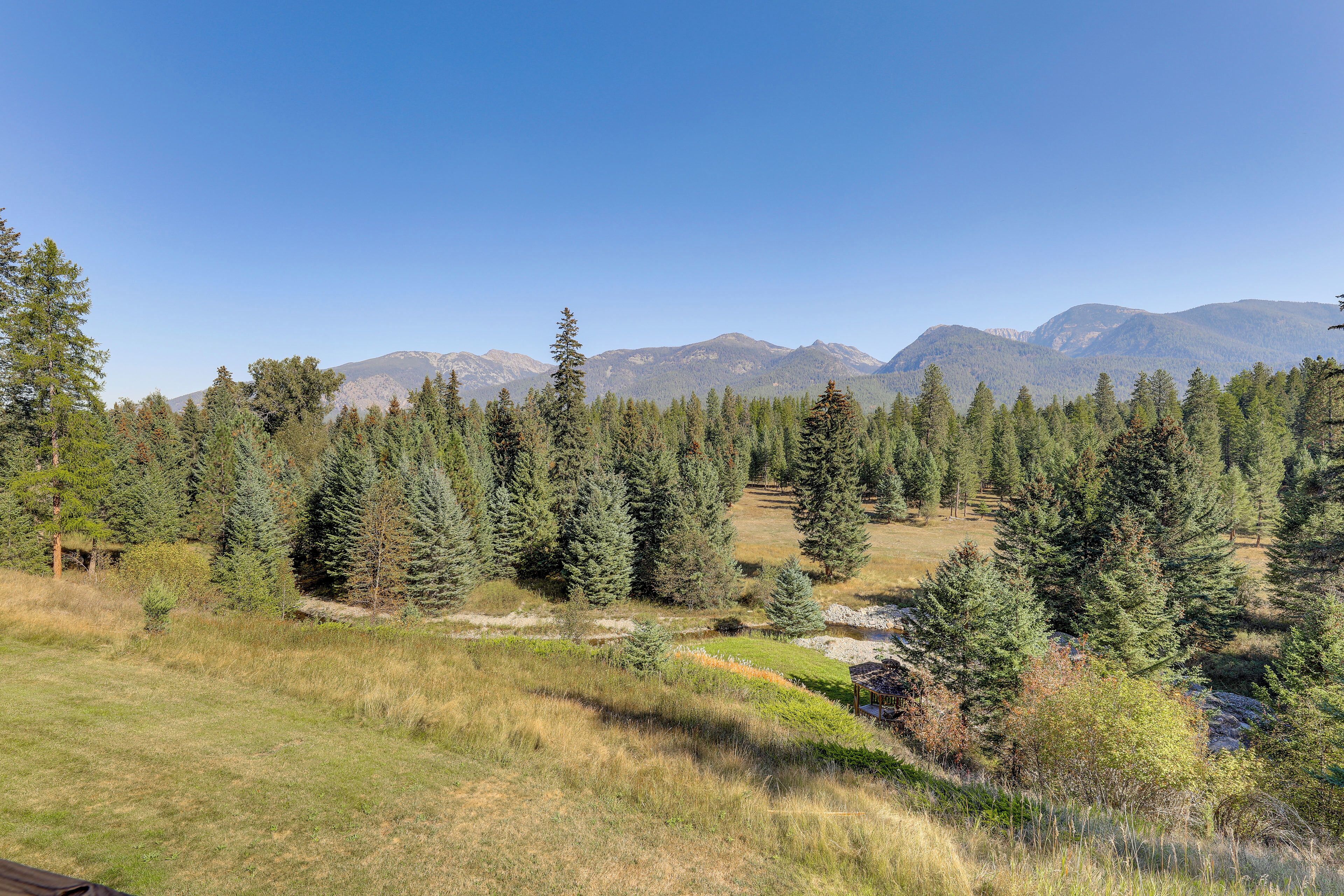 Un paysage montagneux, avec de vastes forêts et un ciel dégagé.