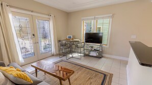 A living room with a sofa, coffee table, TV, and dining area.