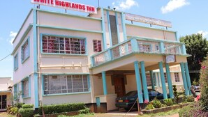 A two-story building with a sign reading "WHITE HIGHLANDS INN." - White highlands Inn Eldoret (Eldoret)