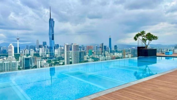 A rooftop infinity pool with a city skyline view, including a prominent skyscraper. - The Riv - Riveria City KL Sentral by Sleepy Bear (Kuala Lumpur)