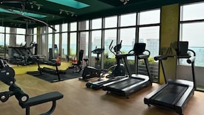 A gym with treadmills, weight machines, and a view of the city. - The Riv - Riveria City KL Sentral by Sleepy Bear (Kuala Lumpur)