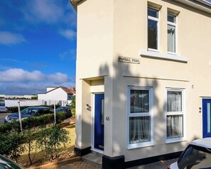 A two-story house with a 'PARNALL ROAD' sign, numbered 65, and a blue door.