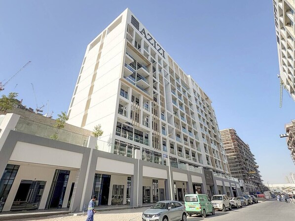 A multi-story hotel with a modern design, featuring balconies and large windows.