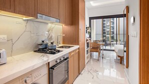 A modern kitchen with wooden cabinets, a marble countertop, and stainless steel appliances.