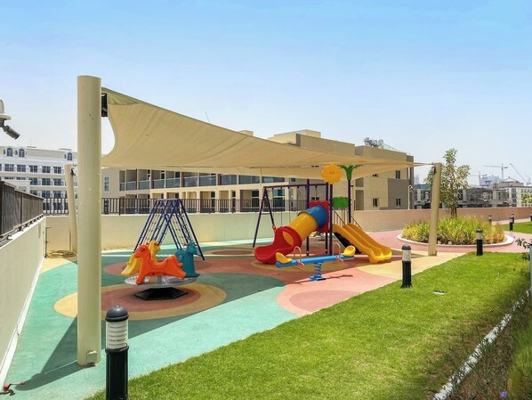 A playground with swings, a slide, and a climbing structure.