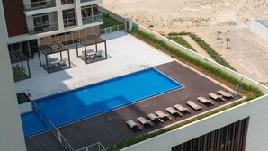A rooftop swimming pool with lounge chairs and a covered seating area. - FIRST CLASS | Studio | Chic & Comfy in Jewelz (Arjan)