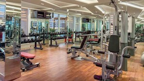 A gym with mirrored walls, various exercise equipment, and a wooden floor. - FIRST CLASS | Studio | Chic & Comfy in Jewelz (Arjan)