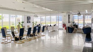 A spacious lobby with a glass wall, a conference table with chairs, and a seating area with sofas. - FIRST CLASS | Studio | Chic & Comfy in Jewelz (Arjan)