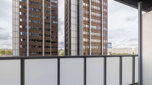 Un balcon avec une balustrade en métal donnant sur de hauts immeubles.