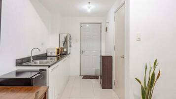 A compact kitchen with a dishwasher, microwave, and sink.