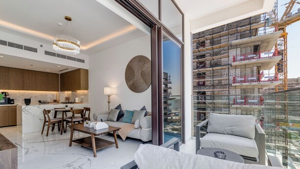 A modern living room with a sofa, coffee table, and dining area. - GLOBALSTAY Azizi Riviera 59 (Dubai)