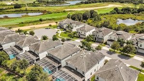 Een woonwijk met huizen met schuine daken en een zwembad.