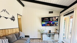 A modern living room with a sofa, a patterned rug, a flat-screen TV, and a wooden ceiling. - Nvh0650 - Woodland Escape 2 Bedroom Home (Stateline)