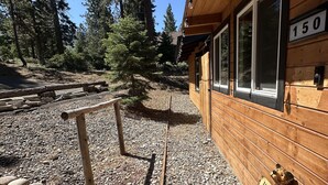 A wooden cabin with a number '150' sign, a welcome bear sculpture, and a gravel path leading to the entrance. - Nvh0650 - Woodland Escape 2 Bedroom Home (Stateline)