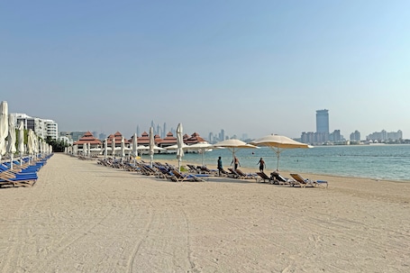 Private beach, white sand, sun loungers, beach umbrellas