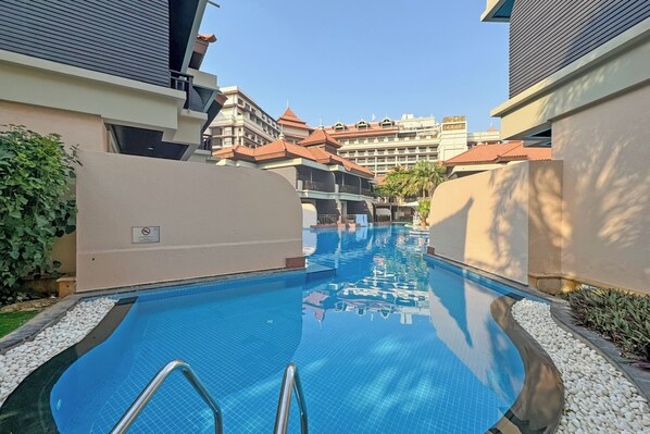 Una piscina al aire libre, sombrillas, tumbonas